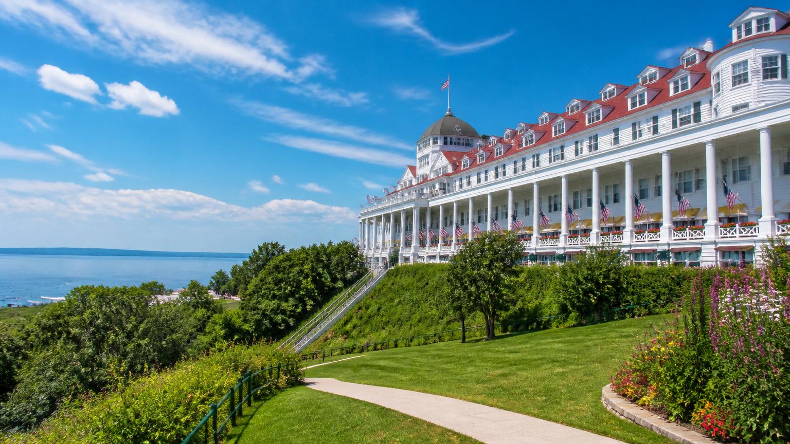Historic Victorian resort with white columns and red roof overlooking the water on Mackinac Island